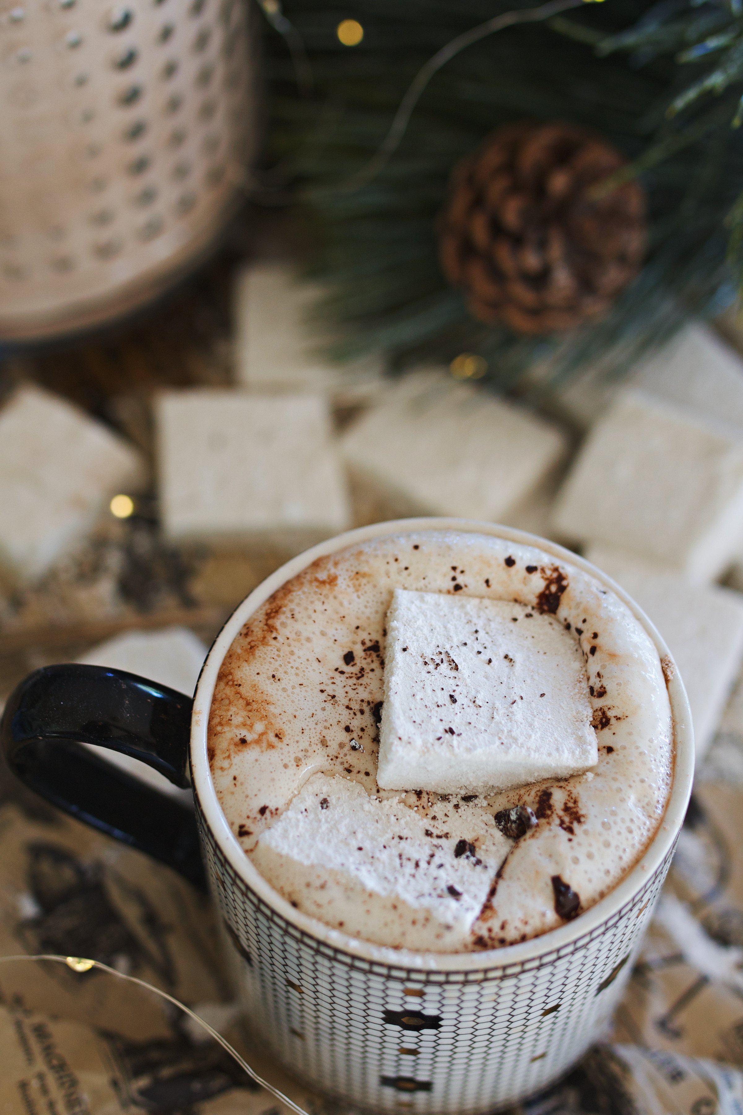 Hot cocoa mix made into a liquid drink with marshmallows on top in a coffee cup.