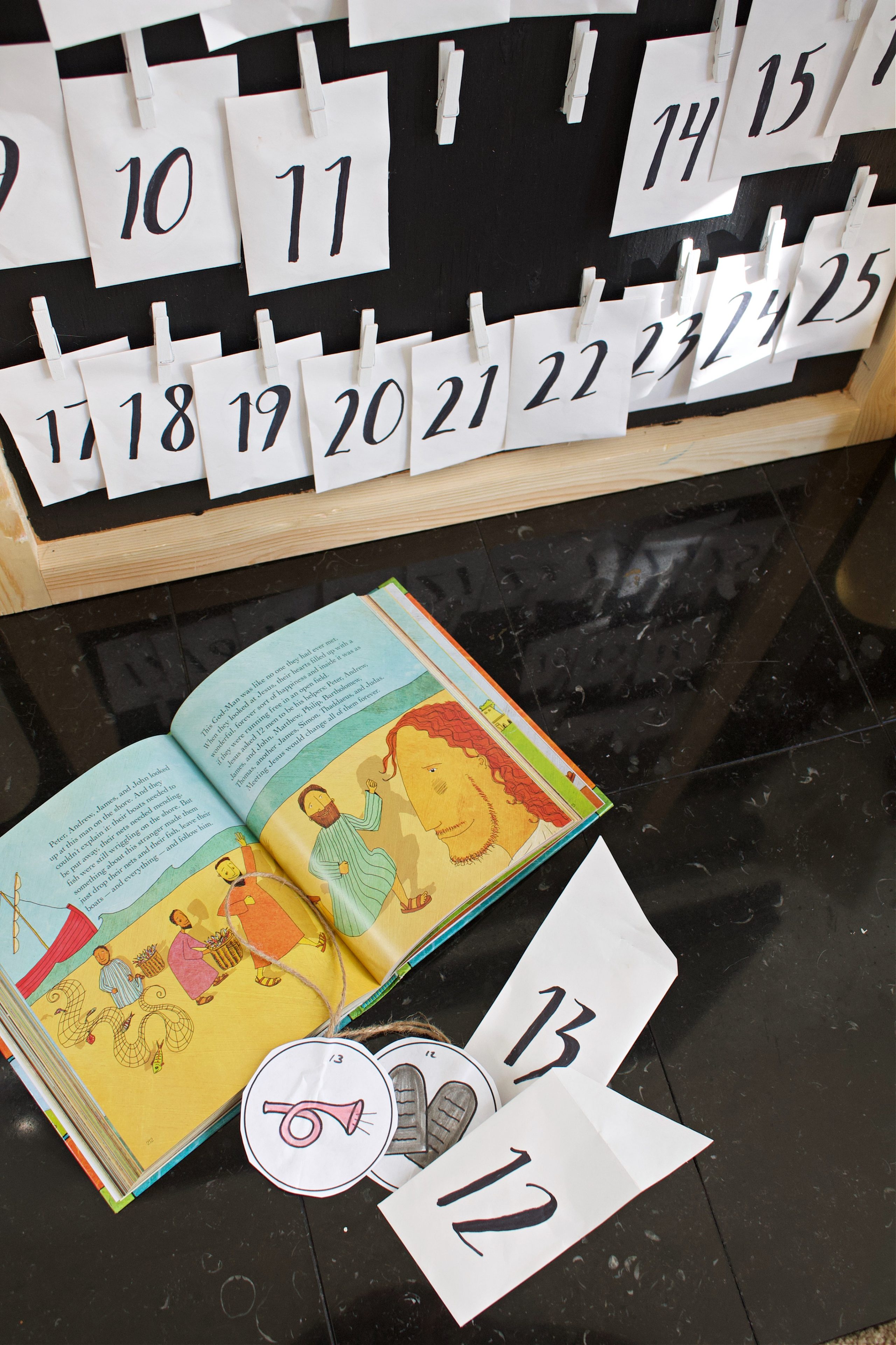 Close up of the bottom half of the advent calendar with the Jesus Storybook Bible opened on the floor.