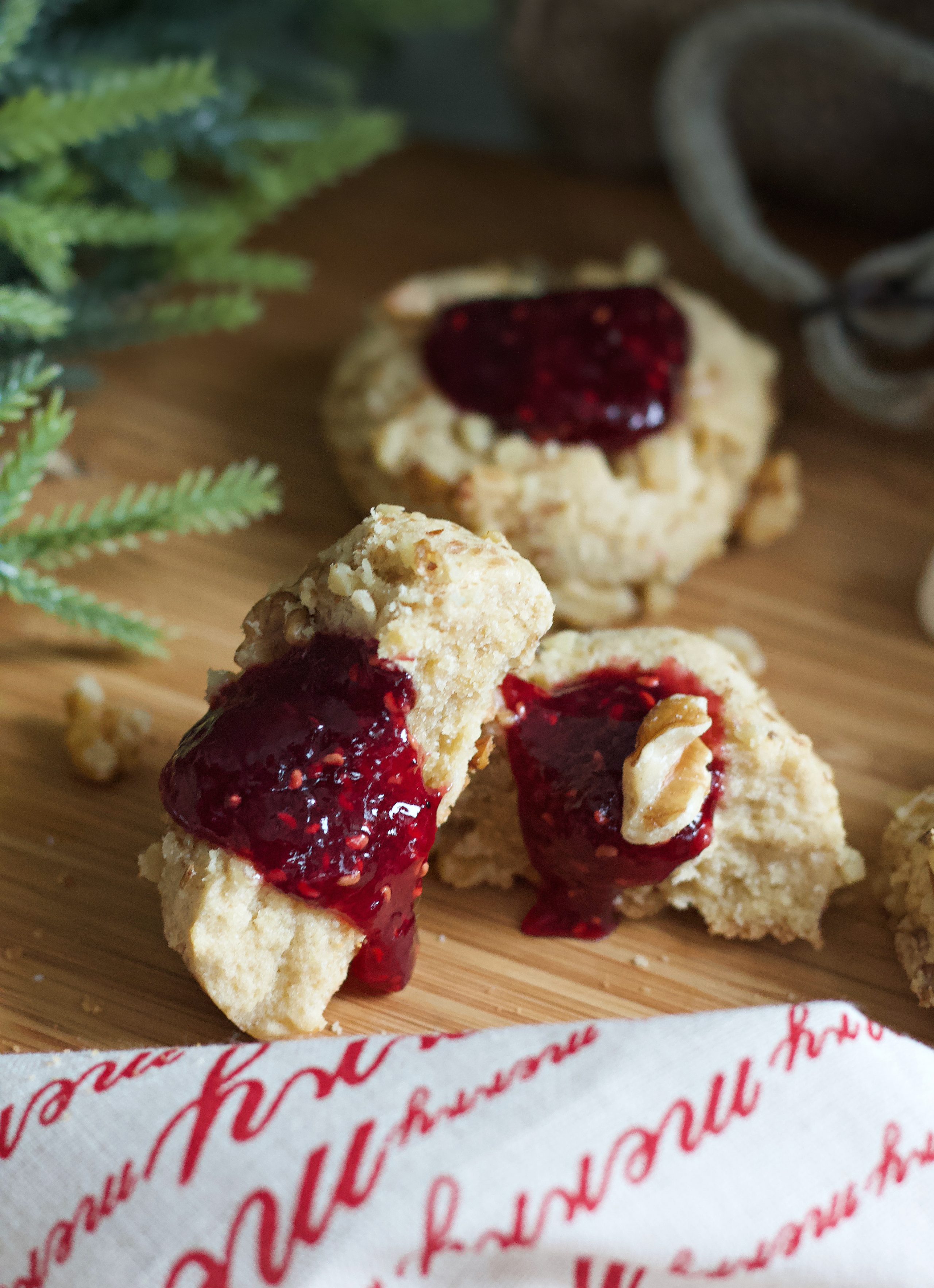 Thumbprint cookie cut in half with preserves running out.