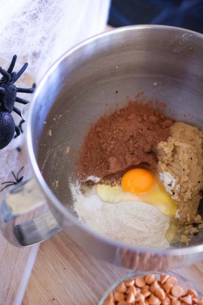 Ingredients including flour, cocoa powder, and egg for a chocolate cookie dough.