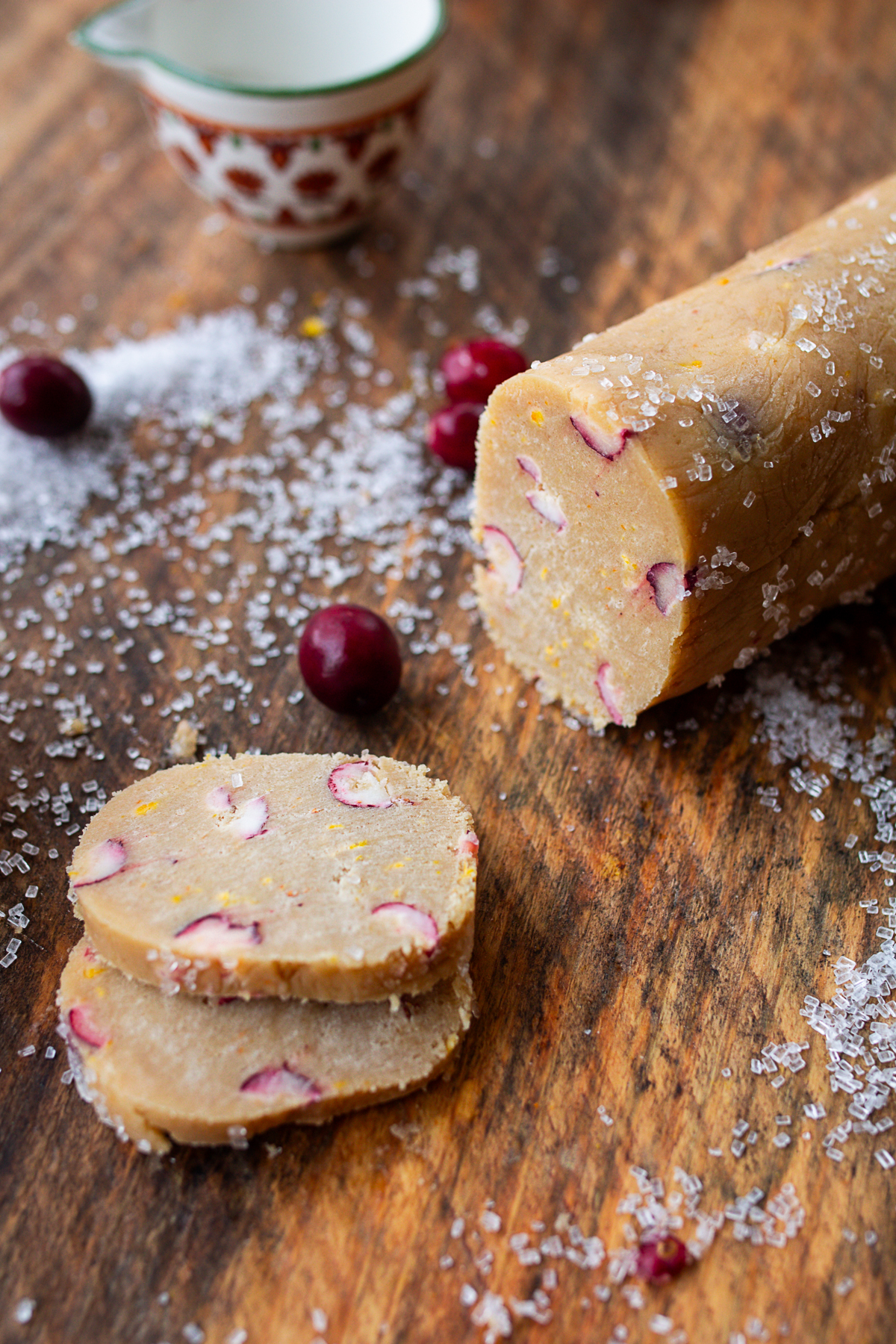 cookie dough log on counter being sliced for baking.