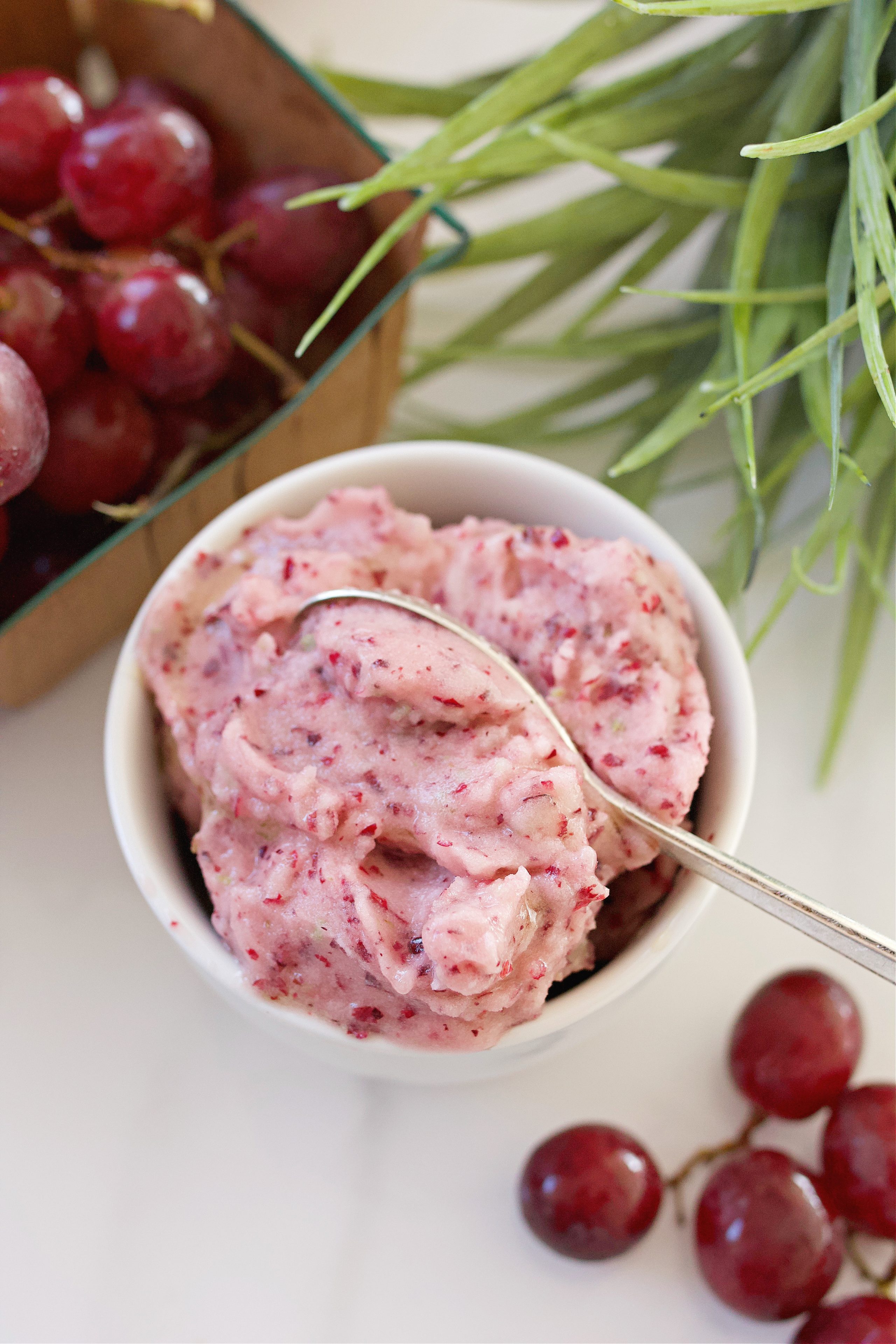 Picture of grape sorbet on counter surrounded by grapes.