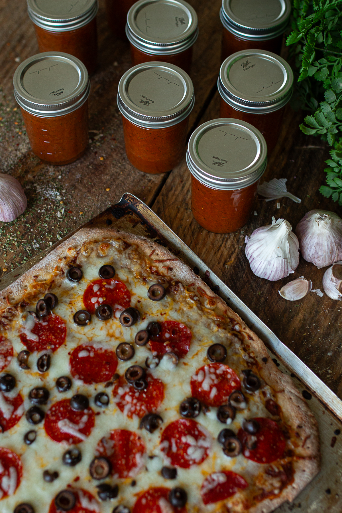Pizza beside cans of pizza sauce.