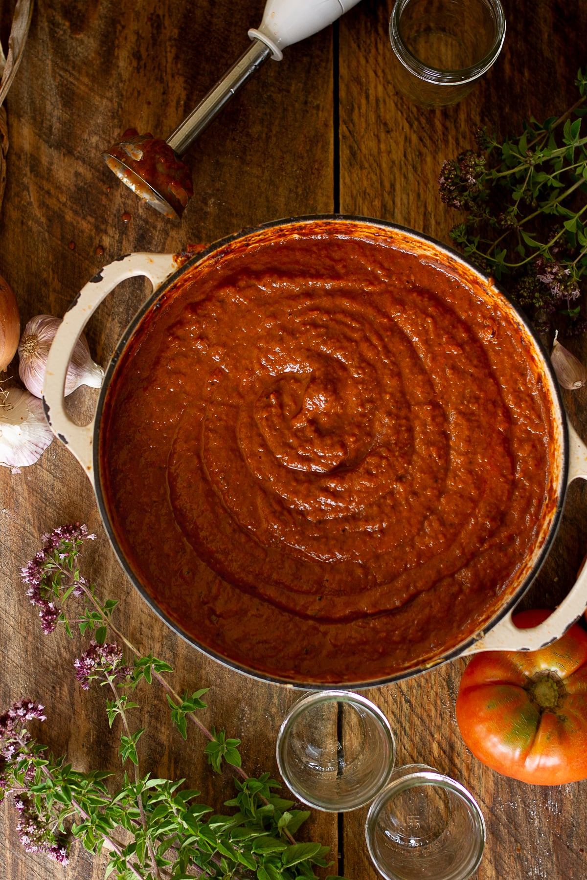Smooth, pureed homemade pizza sauce inside a large stockpot after being blended with an immersion blender, showing a rich and thick velvety texture.