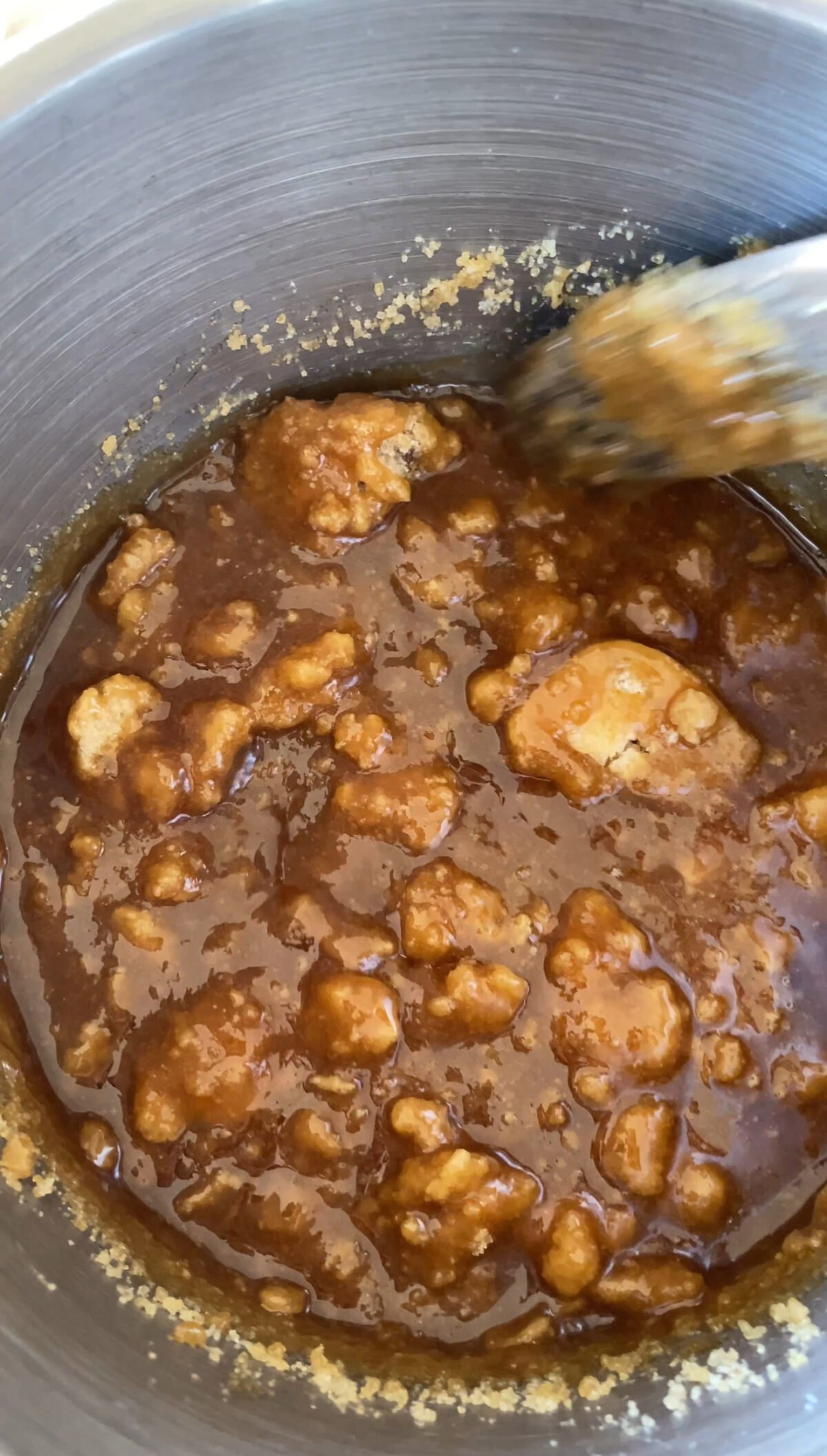 White sugar being melted down in saucepan.