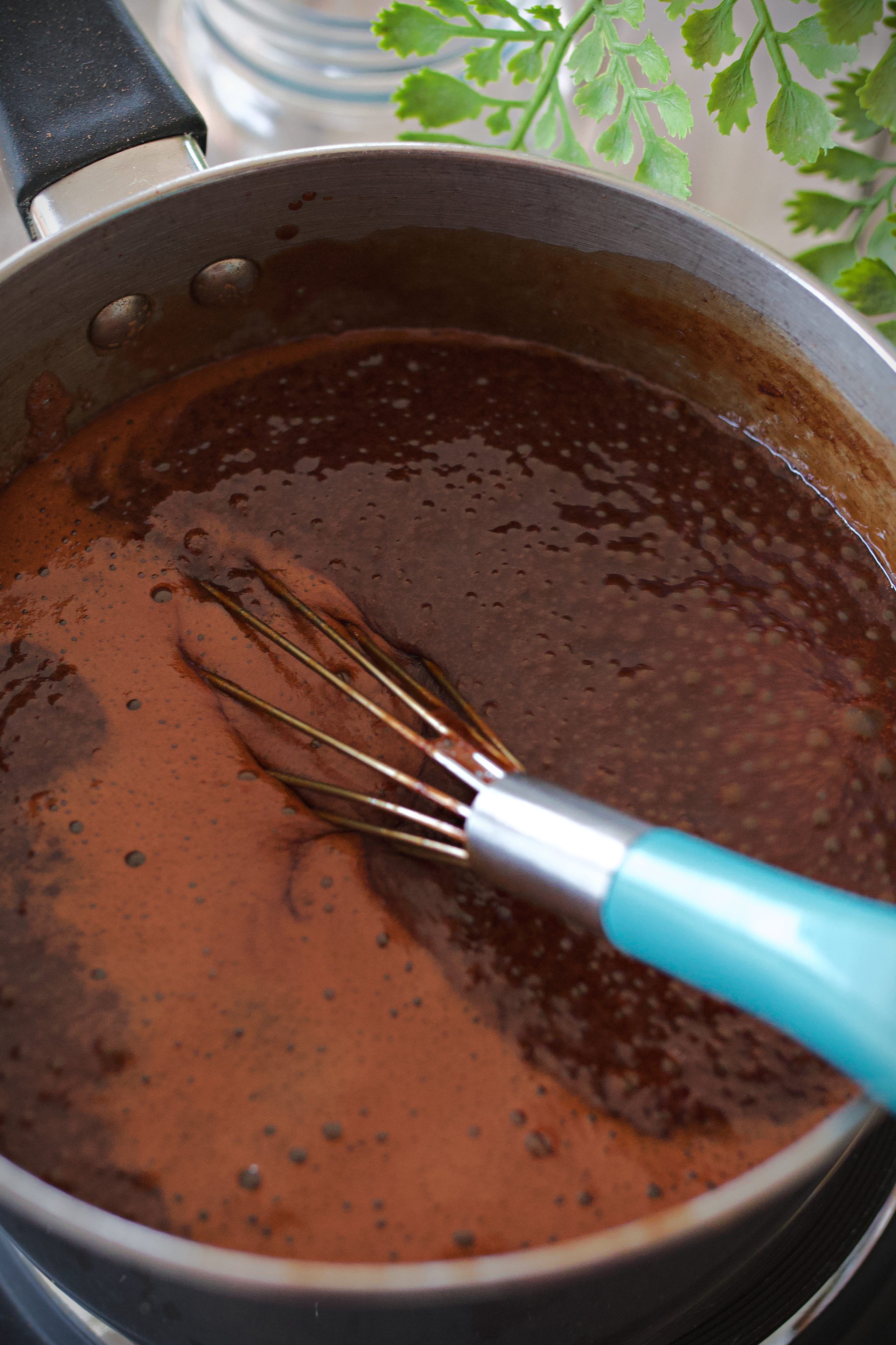 Saucepan with chocolate syrup boiling.