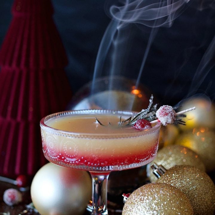 Cranberry orange spritzer drink in champaign glass on table.
