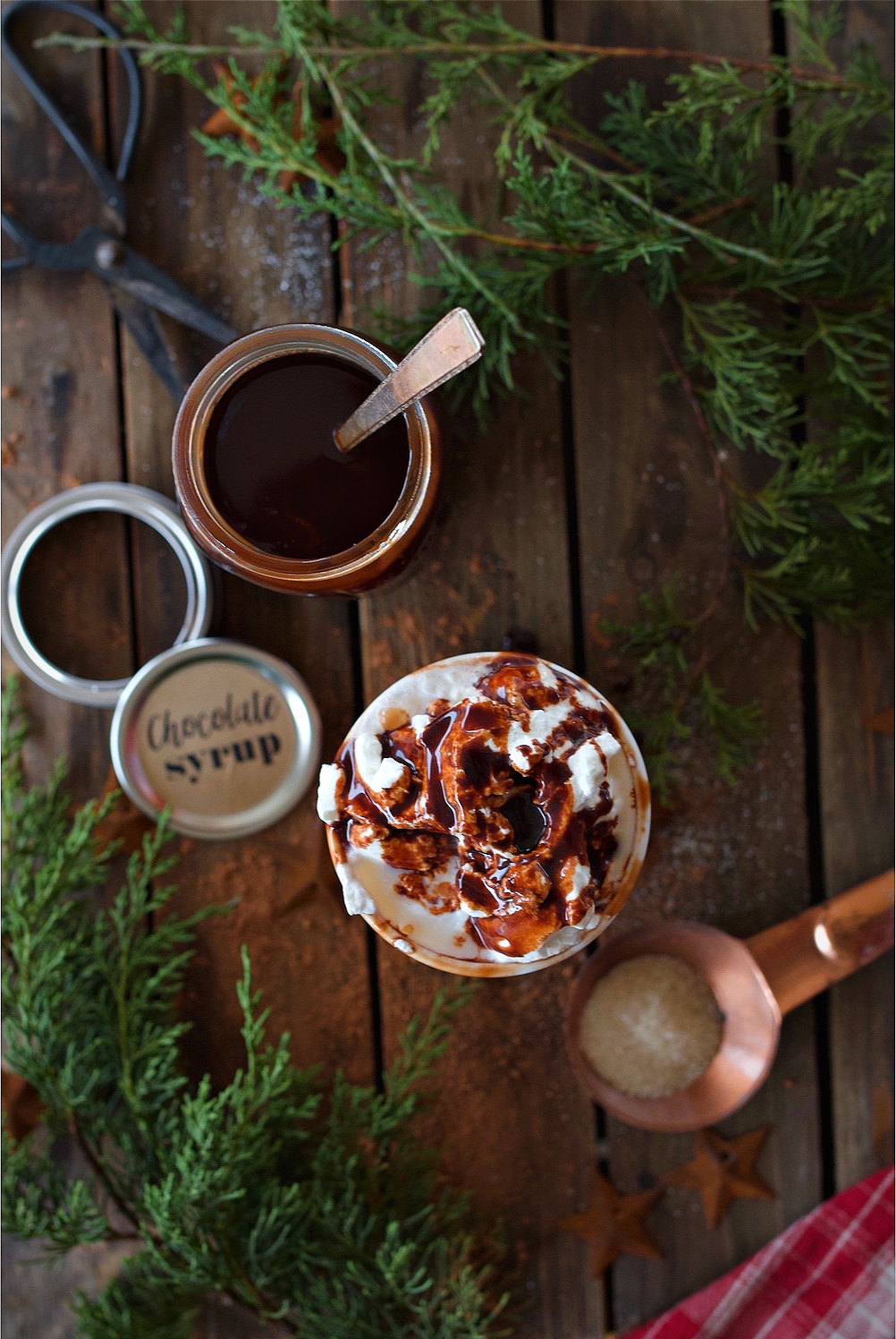 Overhead shot of cup filled with milk, whipped cream, and drizzled with chocolate syrup.