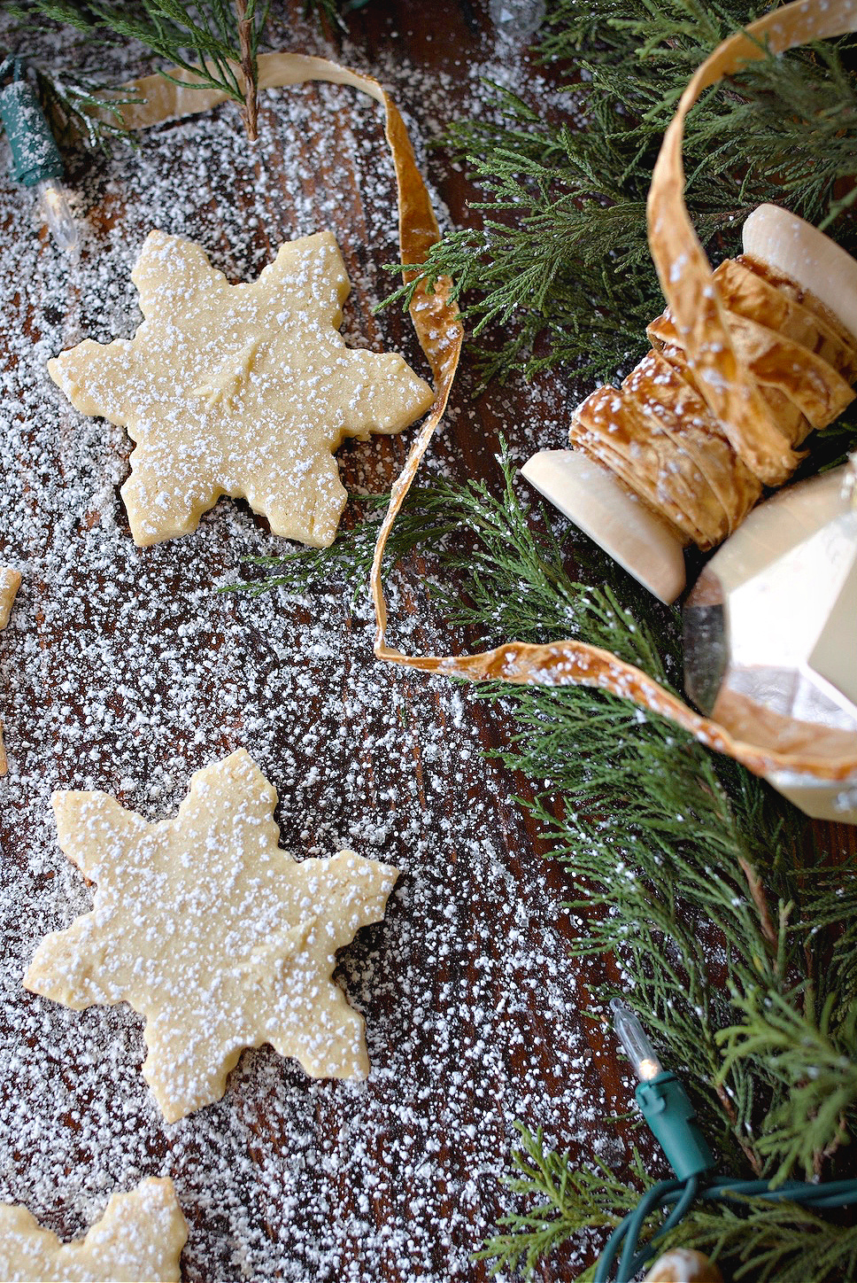 Close up of baked cookies on counter dusted with powdered sugar.