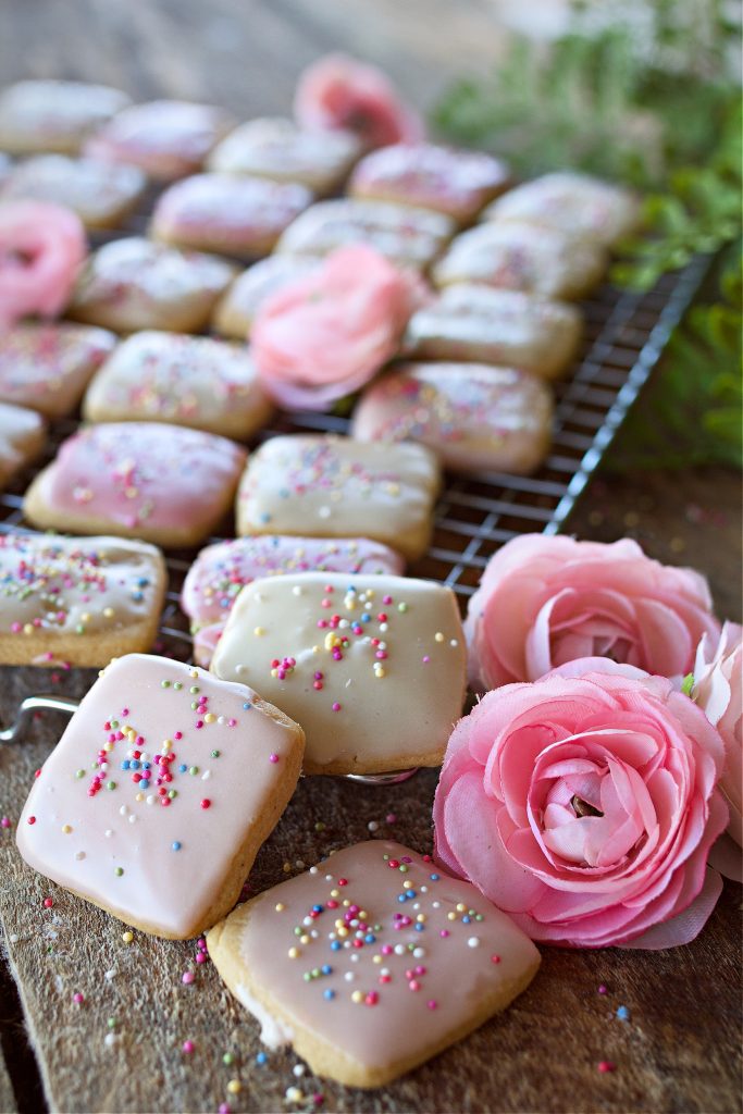 Frosted cookies with flowers on table.