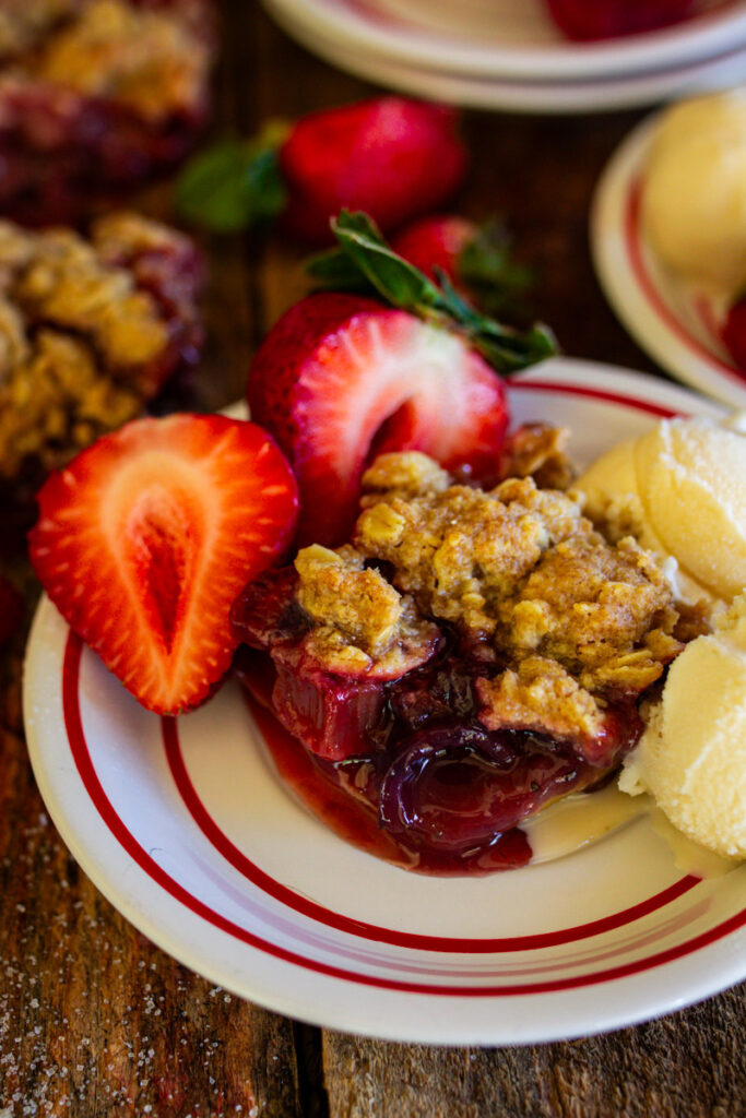 Plated strawberry rhubarb crisp with ice cream.
