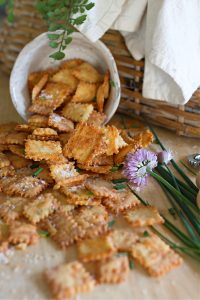 Homemade Cheez its pouring out of ceramic bowl onto counter.