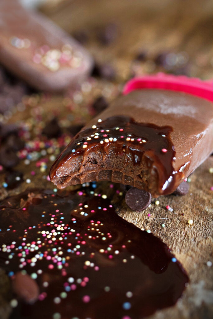 fudge popsicle with chocolate syrup and sprinkles on the end