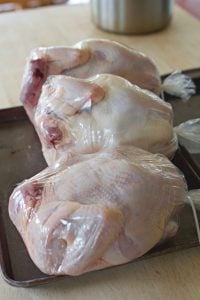 shrink wrapped whole chickens on counter.