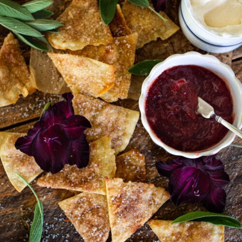 cinnamon sugar chips on counter next to a jam and whip cream dip.