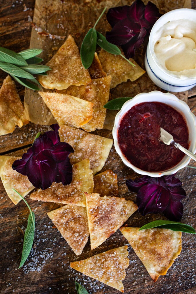 cinnamon sugar chips on counter next to a jam and whip cream dip.