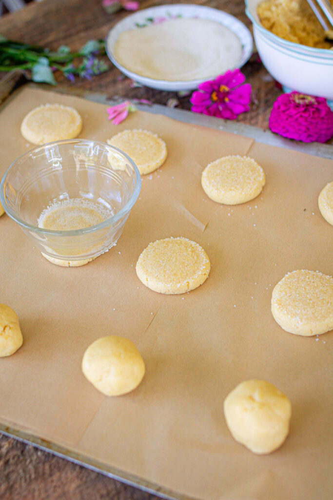 flattening cookie dough balls to prepare for baking.