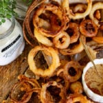 onion rings spilling out of a basket onto a wooden counter.