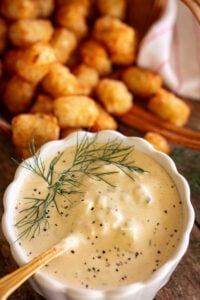 tartar sauce front and center with tater tots next to it.