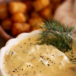 homemade tartar sauce along side a basket of tater tots.