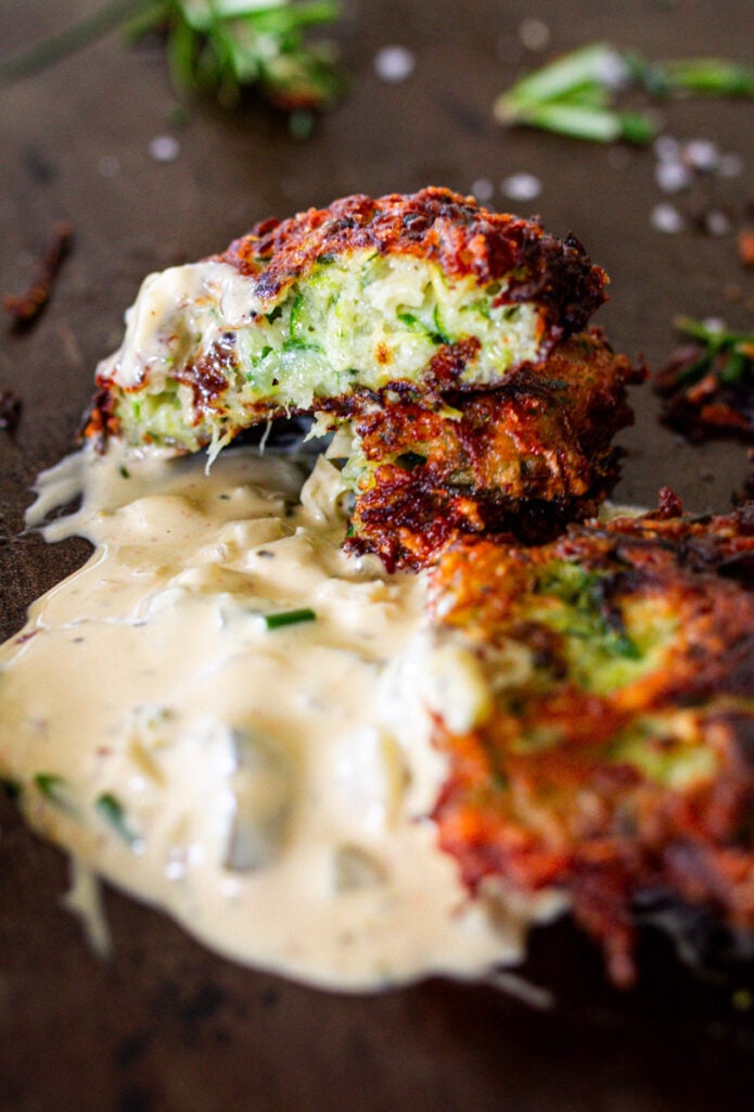 Zucchini Fritters with tartar sauce on pan ready to eat.