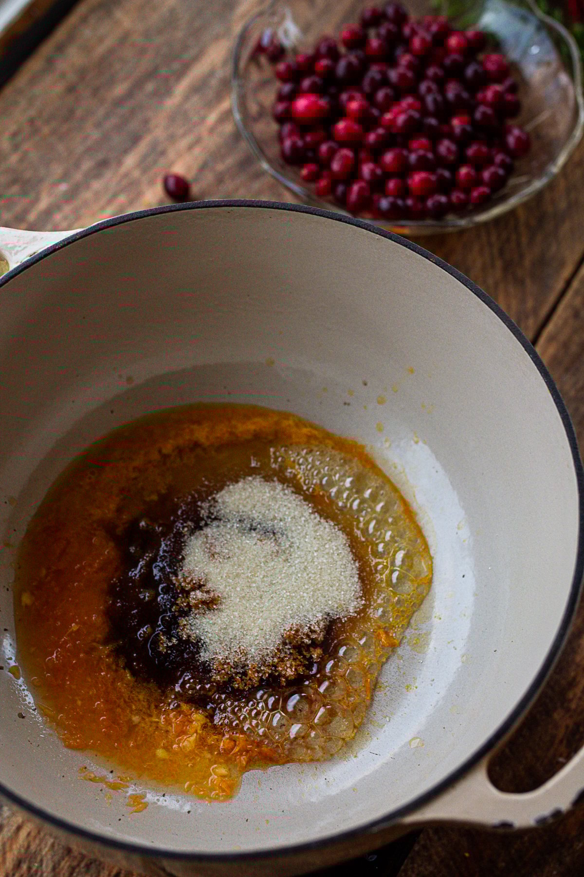 sugars and juice in cast iron stew pot melting together before adding cranberries.