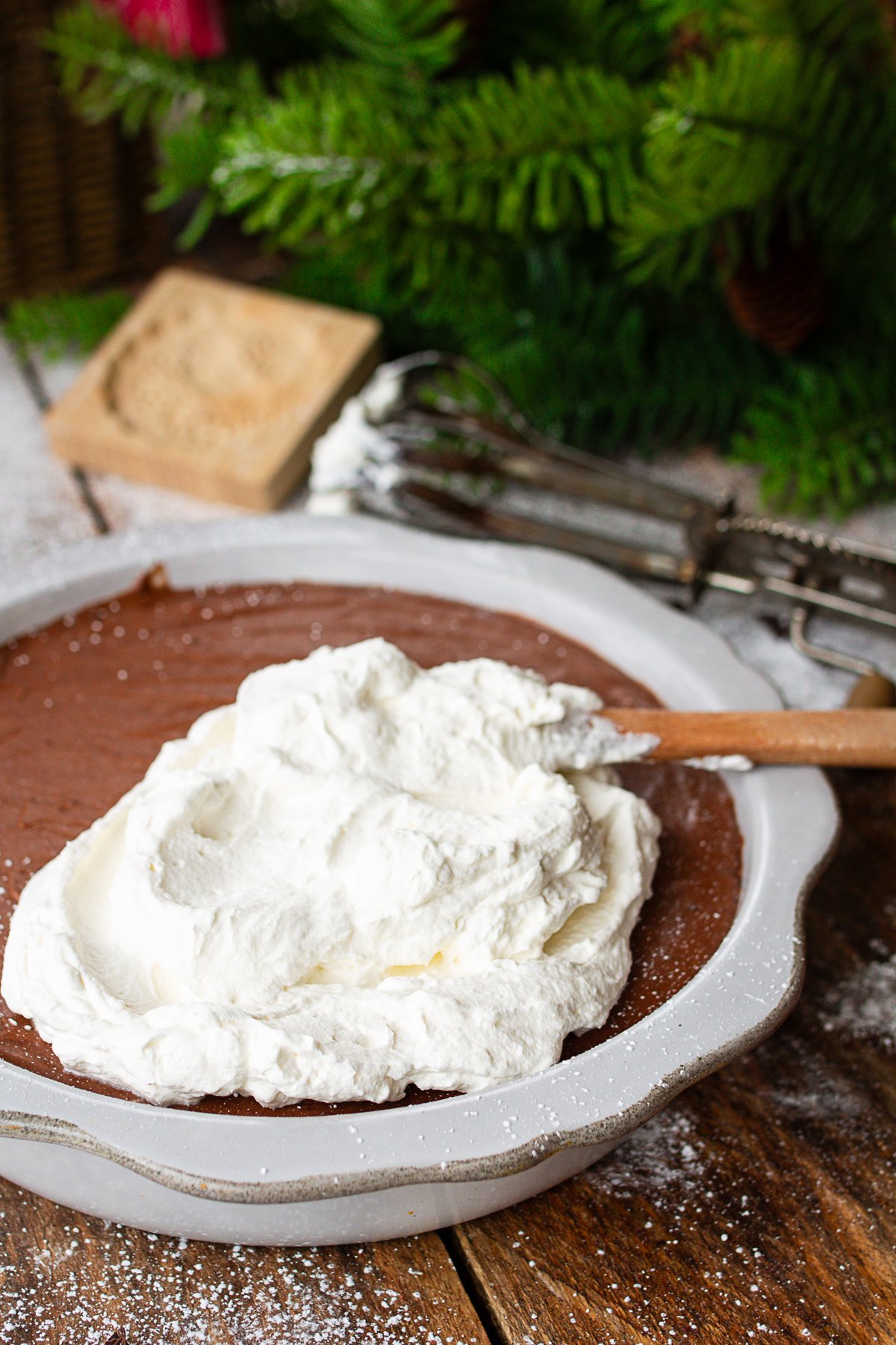 whipping cream on top of pie ready to spread out and serve.