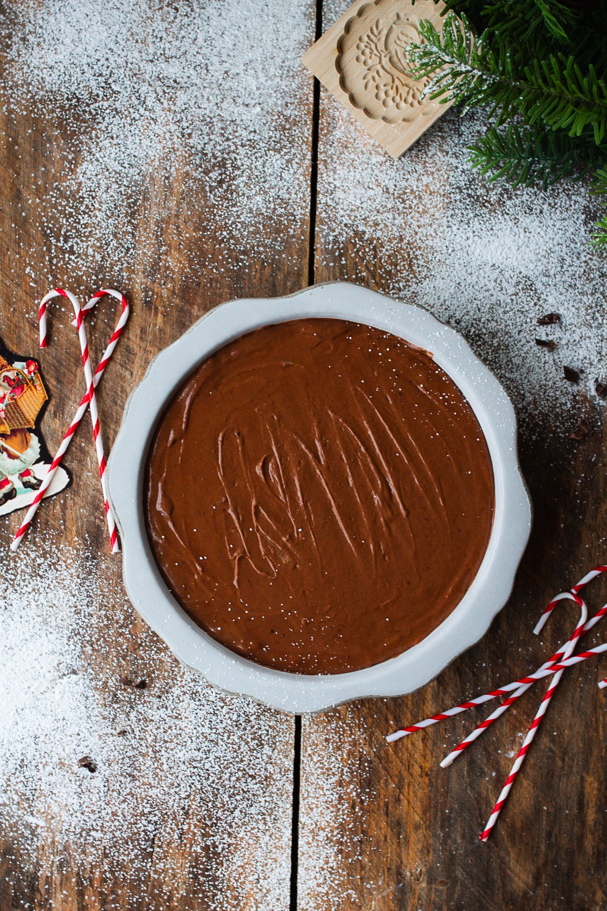 Chocolate silk pie filling in pie crust on counter.
