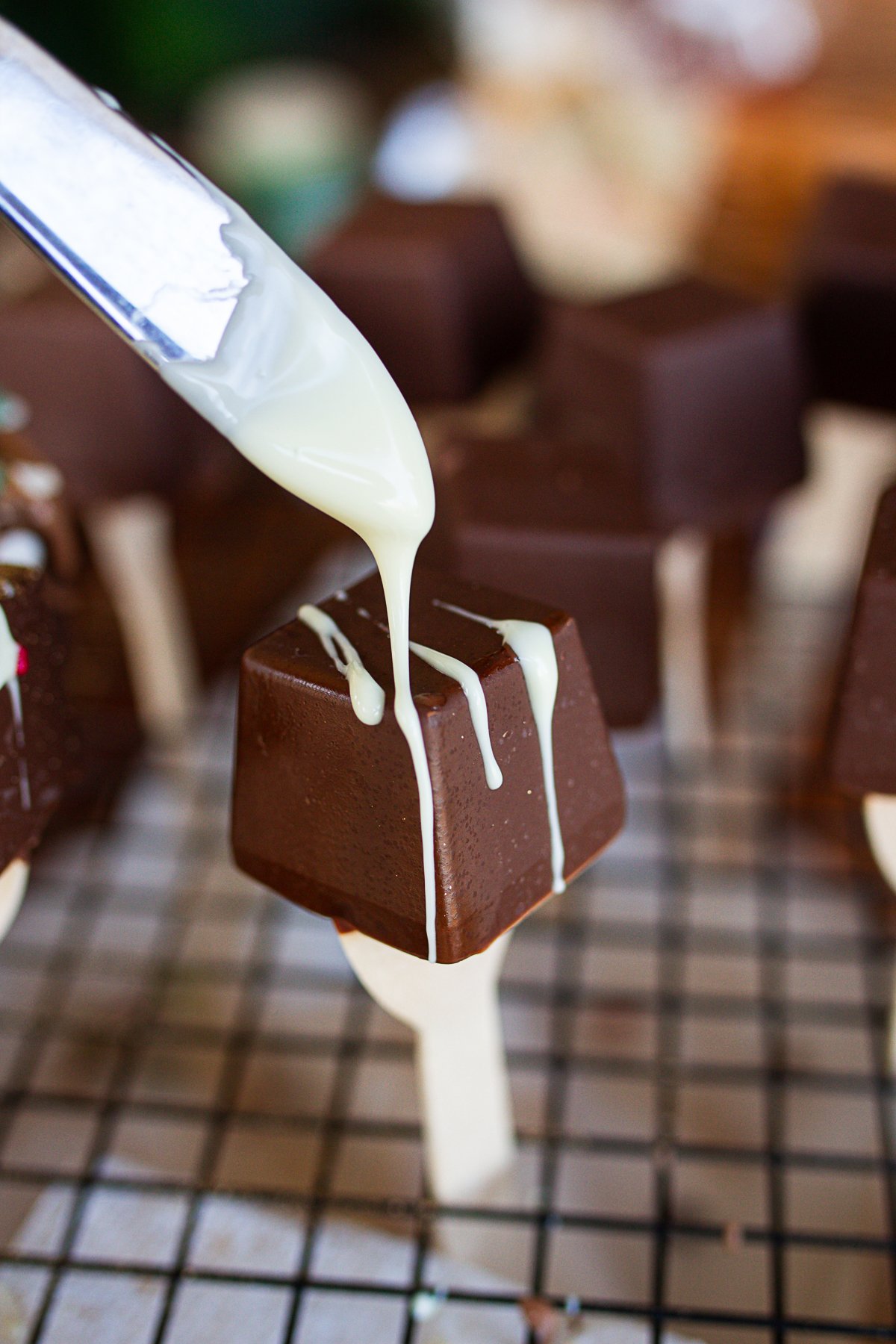 Drizzling white chocolate over hot cocoa spoon.