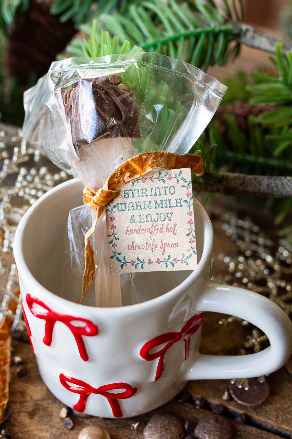 Hot chocolate spoon wrapped in cellophane with a tag on the front that says "Stir into warm milk and enjoy".