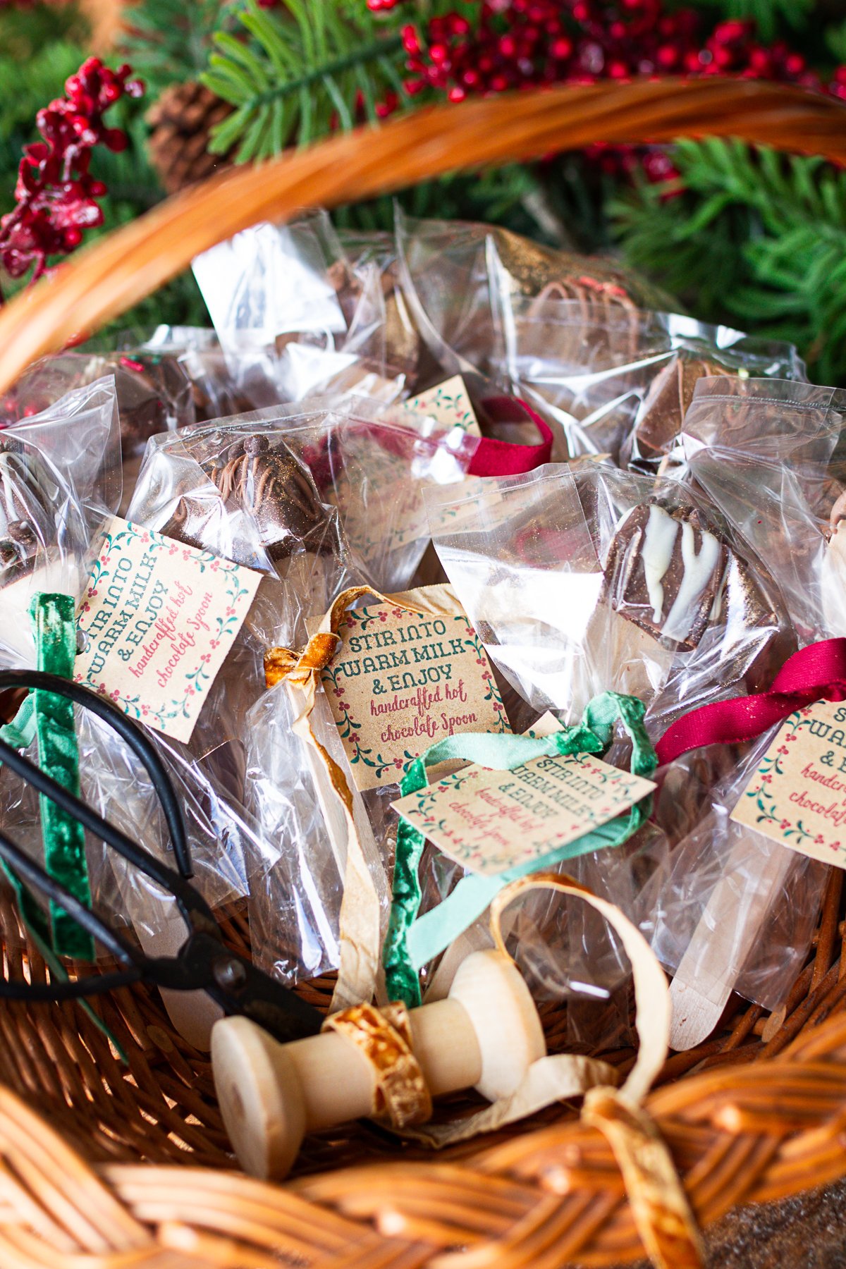 Chocolate spoons wrapped and tagged in a basket ready for gifting.