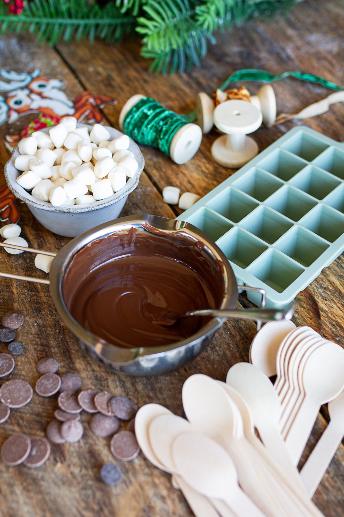 Melted chocolate and ingredients on counter to make cocoa spoons.
