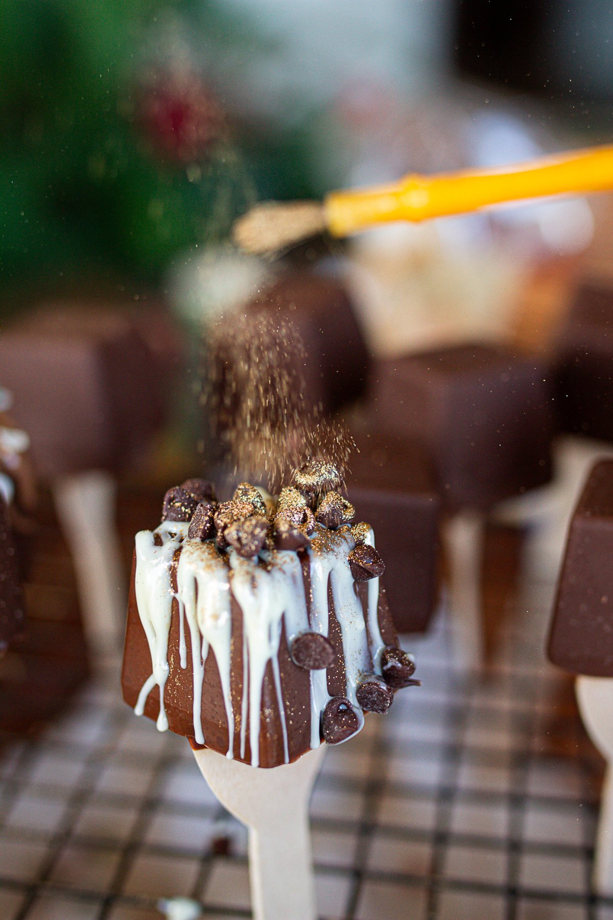 Dusting gold glitter onto of hot cocoa spoon.