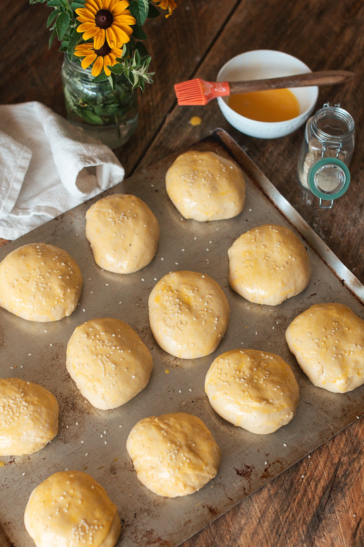 Divided portions of brioche dough on a pastry mat with a bench scraper.