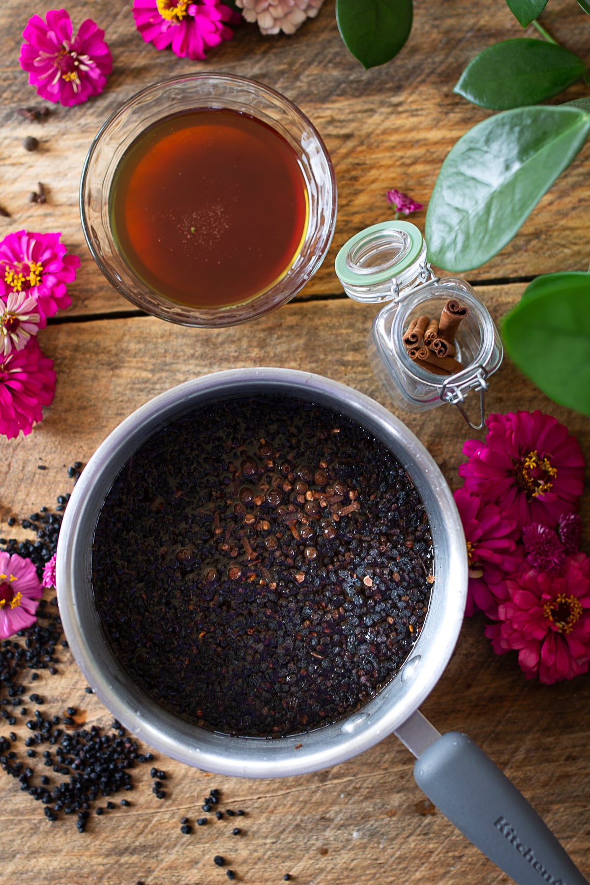 Cooked elderberries and spices simmered in a saucepan for homemade elderberry syrup