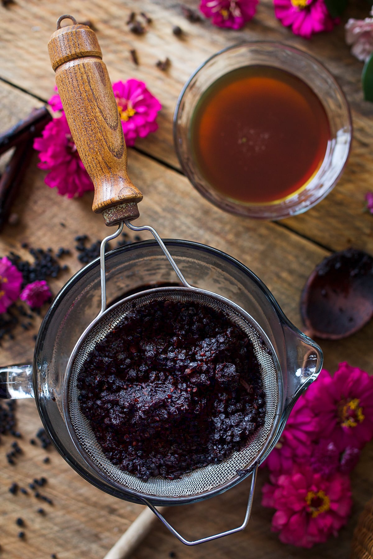 Cooked elderberries pressed through a fine mesh strainer for homemade elderberry syrup