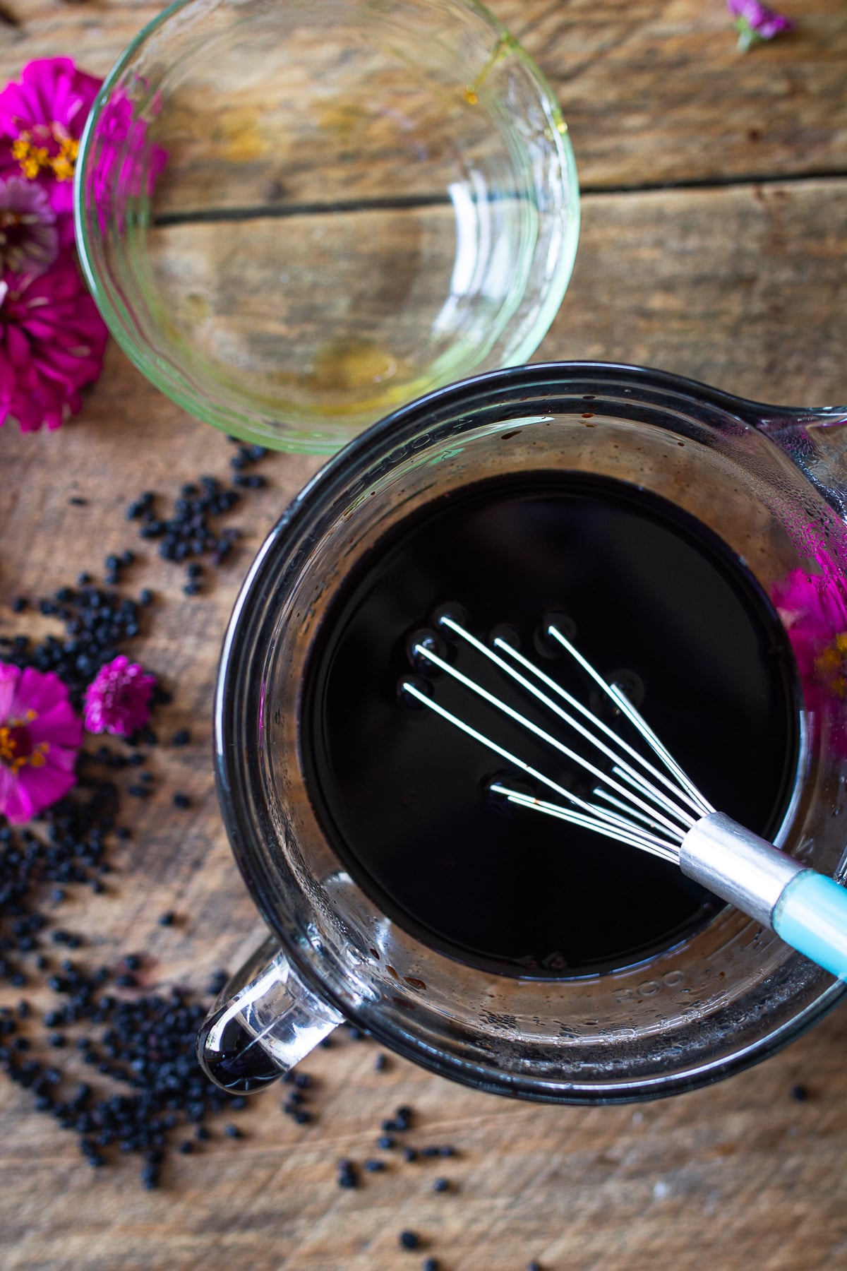 Honey whisked into strained elderberry liquid to make homemade elderberry syrup