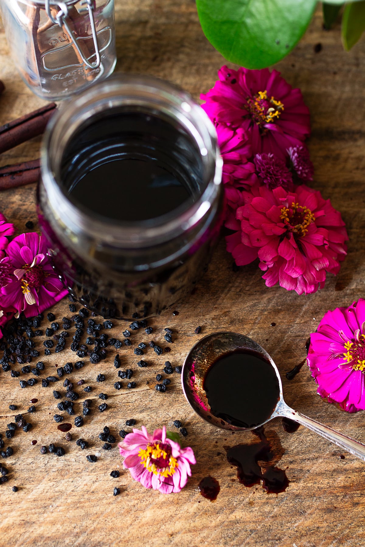 Homemade elderberry syrup in a mason jar with a tablespoon serving