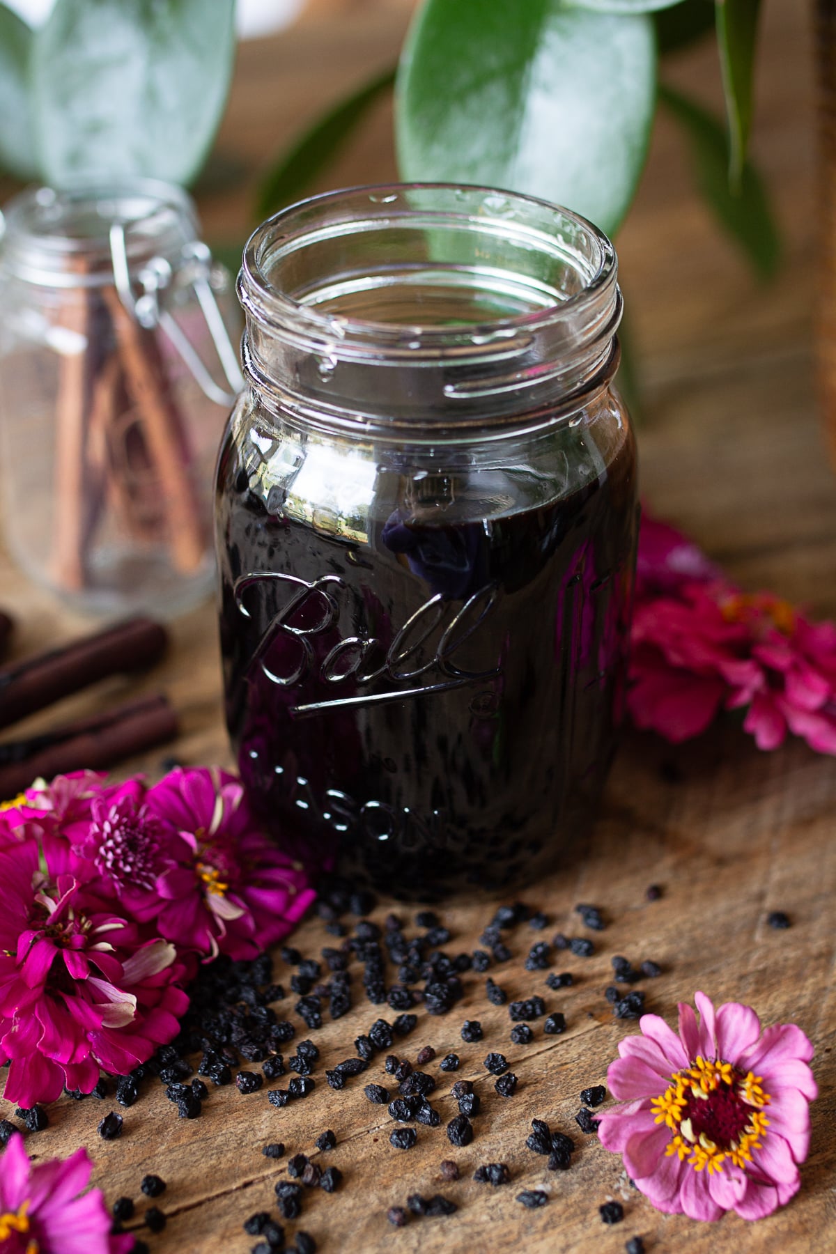 Dark homemade elderberry syrup served from a glass mason jar