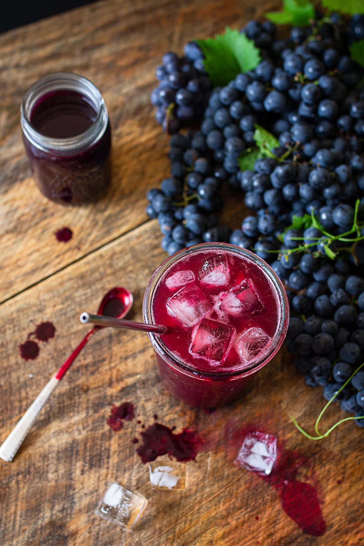 Homemade Concord grape juice served over ice with grape juice concentrate and fresh grapes